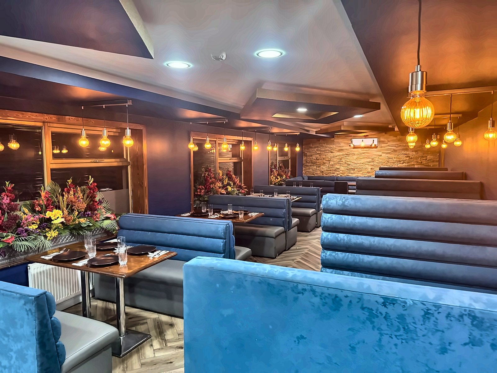 Blue velvet booths under warm pendant lights
